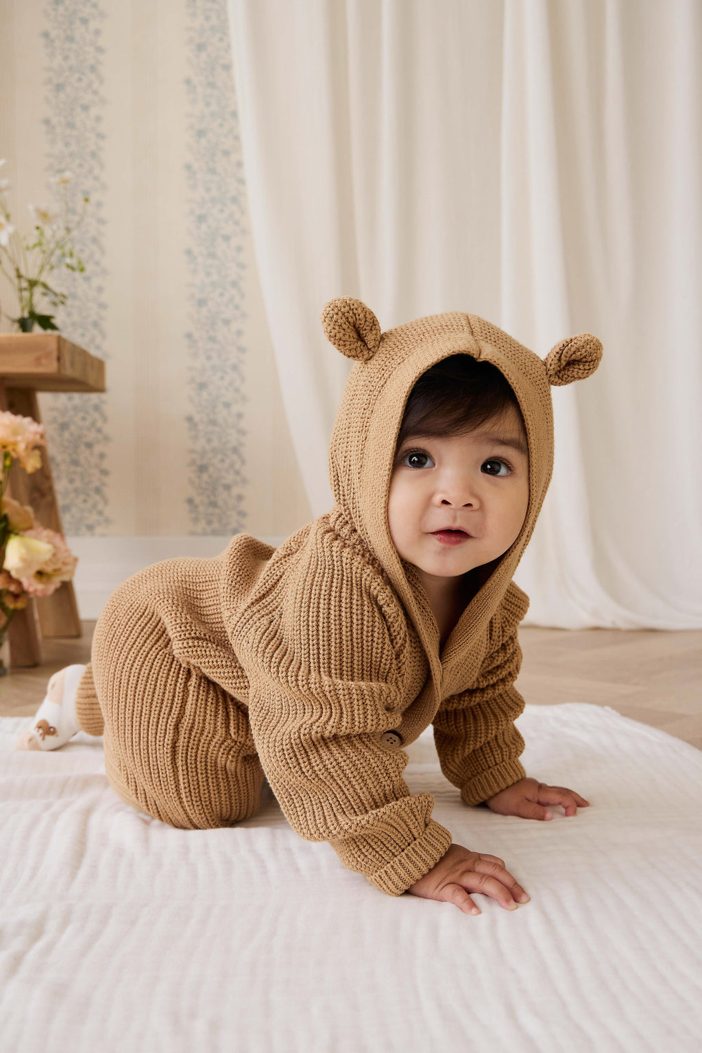 Grenouillère en tricot de coton douillet marron fauve avec capuche, oreilles et boutons sur le devant