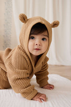 Grenouillère en tricot de coton douillet marron fauve avec capuche, oreilles et boutons sur le devant