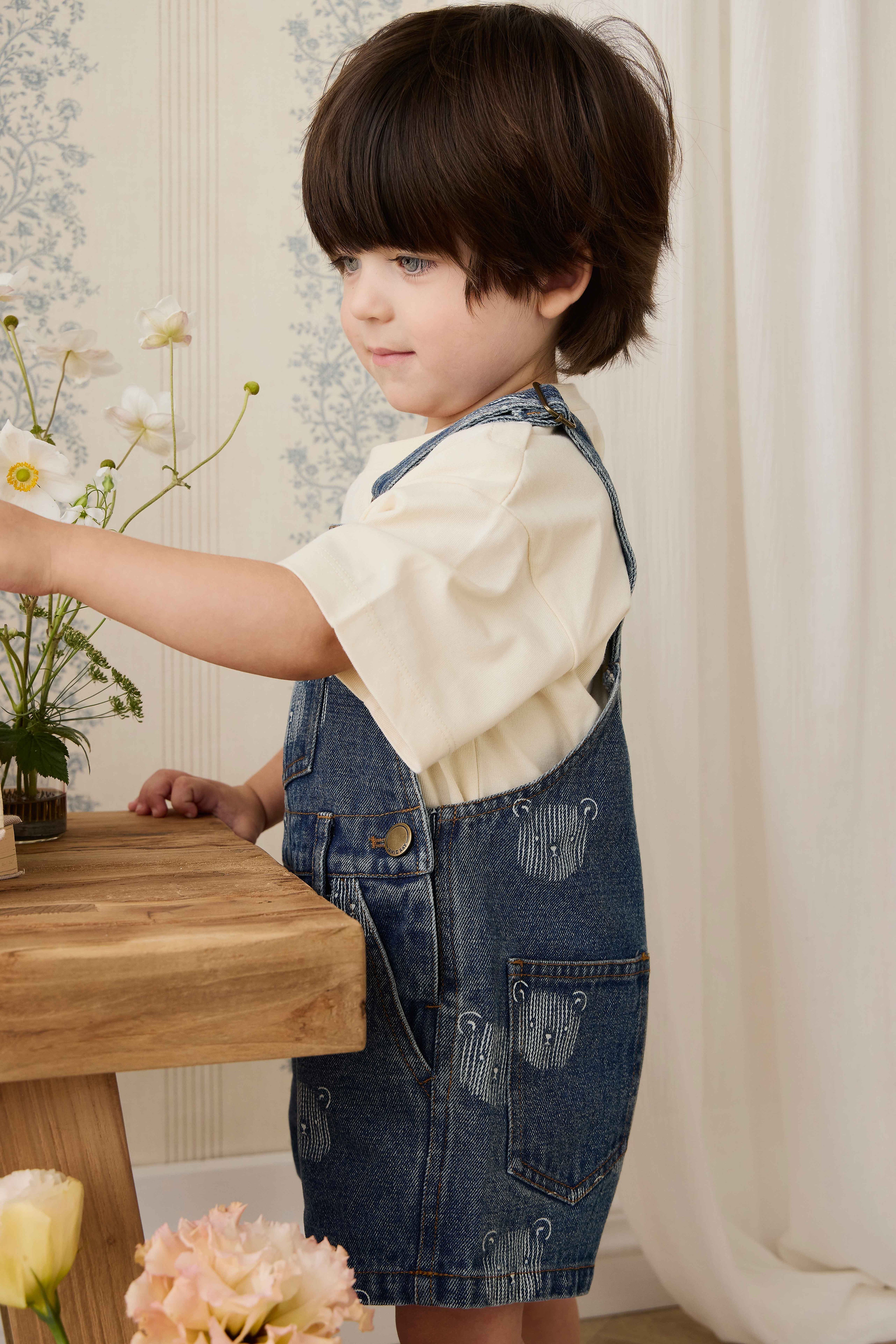 Salopette courte en jean bleu ludique avec imprimé tête d'ourson et bretelles réglables