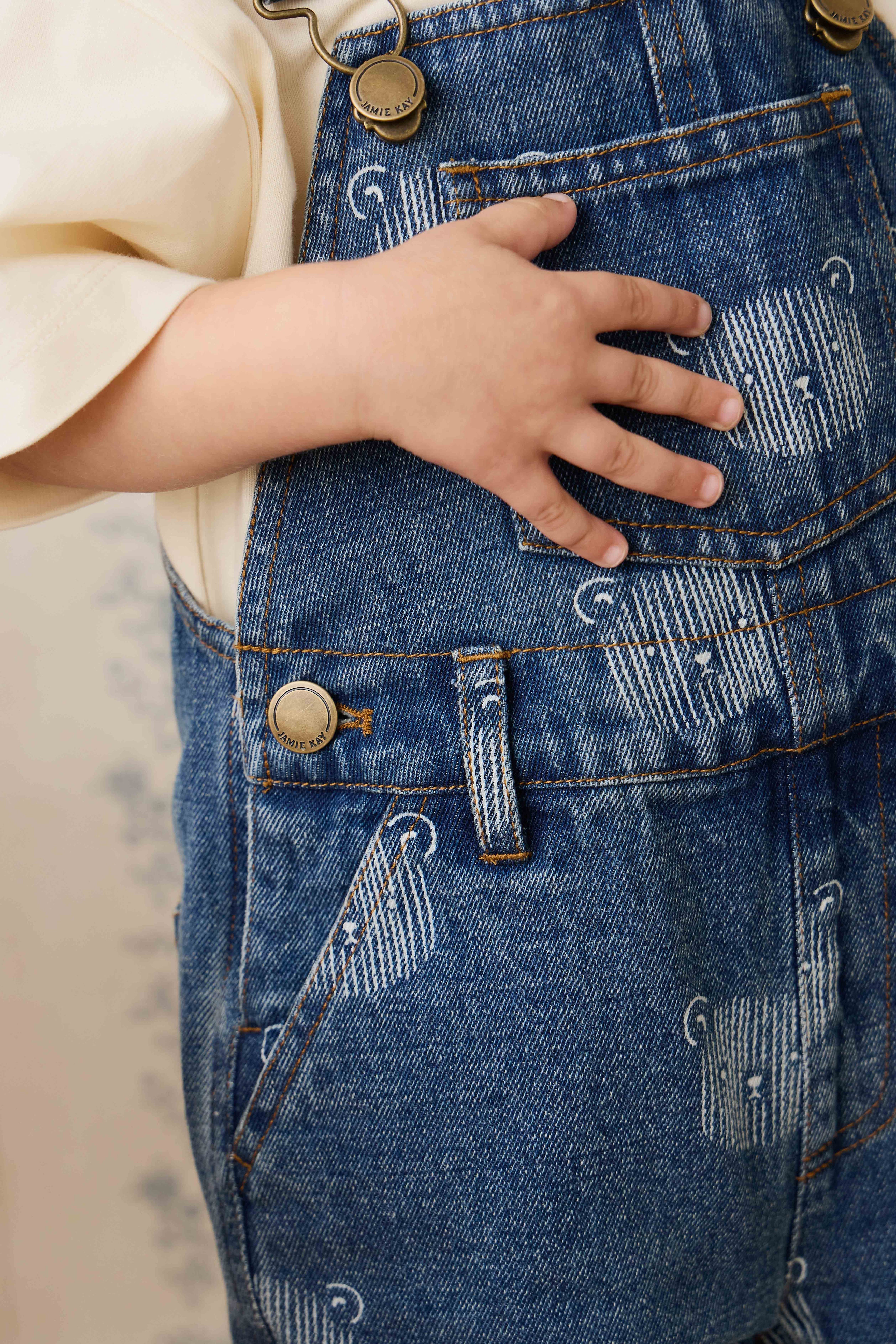 Salopette courte en jean bleu ludique avec imprimé tête d'ourson et bretelles réglables