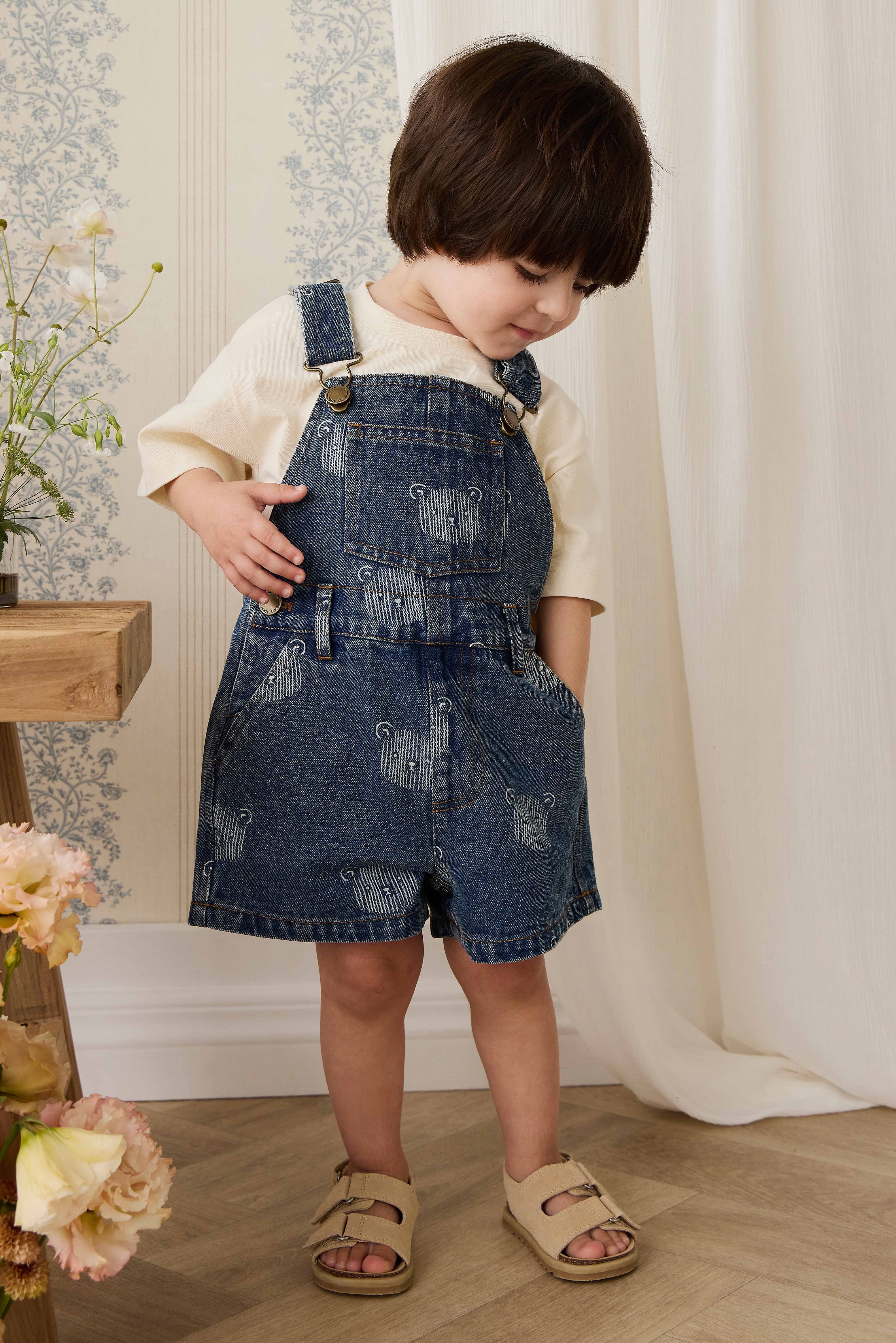 Salopette courte en jean bleu ludique avec imprimé tête d'ourson et bretelles réglables