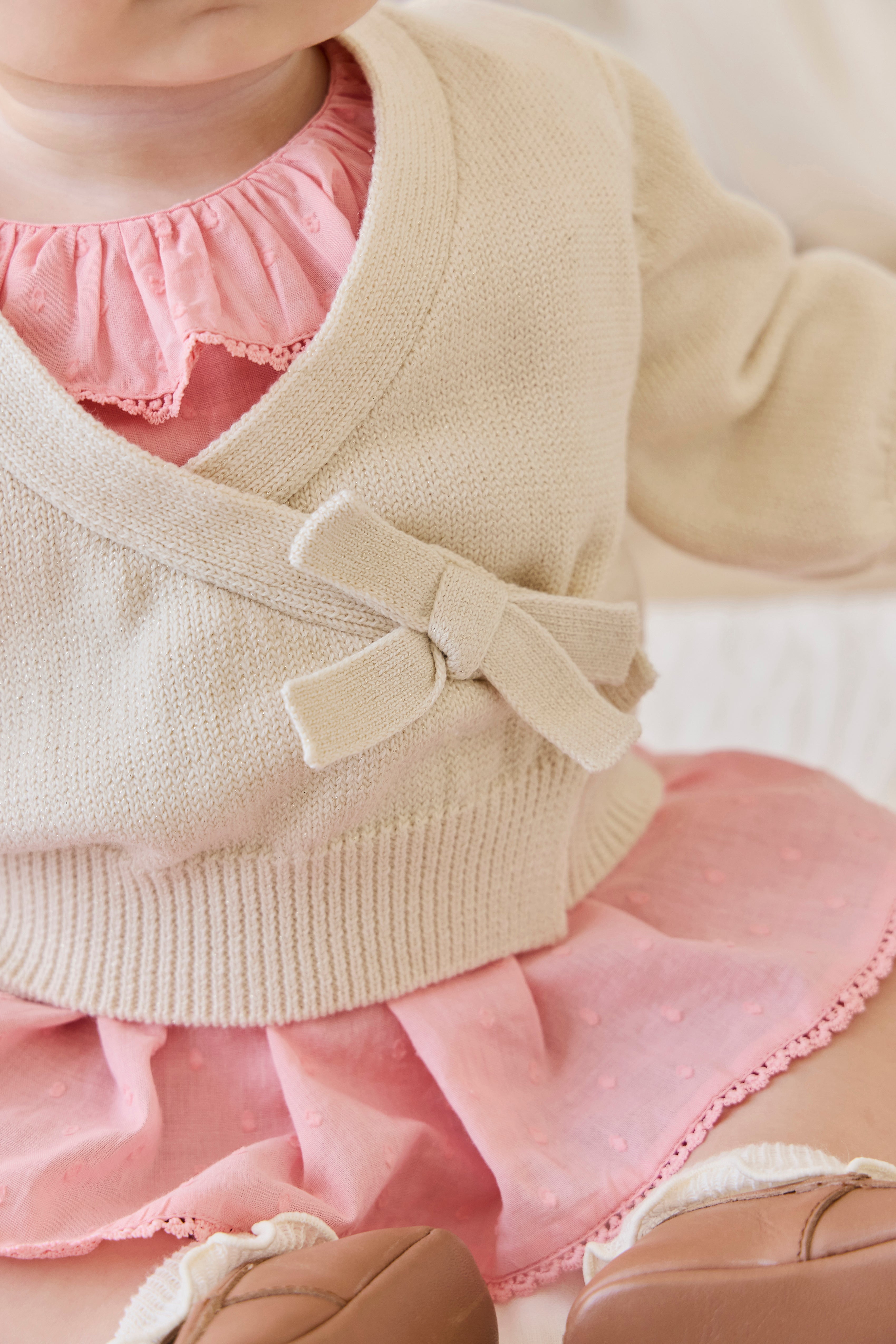 Gilet élégant en coton crème et lurex, avec cache-cœur et manches ballon