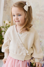 Gilet élégant en coton crème et lurex, avec cache-cœur et manches ballon