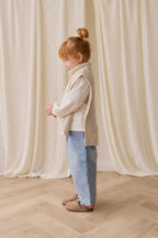 Poncho classique en coton vanille à mailles torsadées avec col roulé et boutons sur le devant