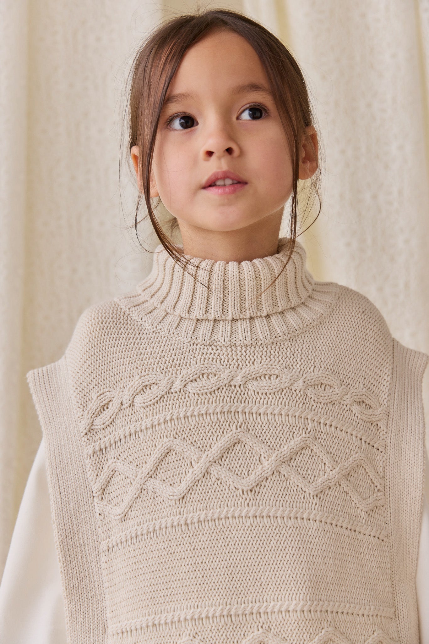 Poncho classique en coton vanille à mailles torsadées avec col roulé et boutons sur le devant