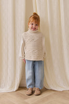 Poncho classique en coton vanille à mailles torsadées avec col roulé et boutons sur le devant