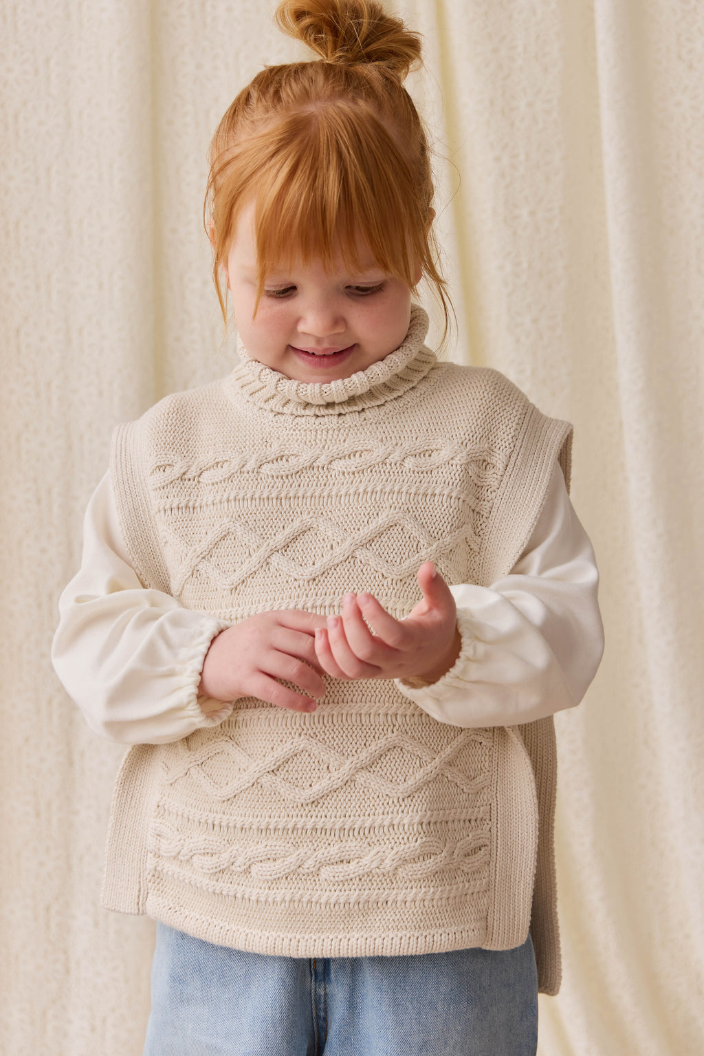 Poncho classique en coton vanille à mailles torsadées avec col roulé et boutons sur le devant